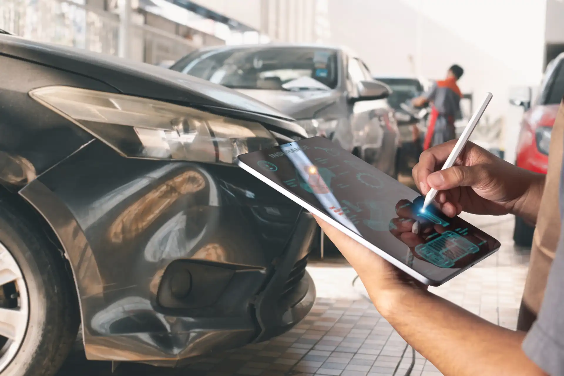 Ein Mitarbeiter begutachtet das Auto mit einem Tablet in der Hand